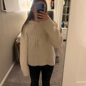 Beige stickad hoodie - Mysig beige stickad hoodie med huva och snörning. Tröjan har lång ärm och en relaxed passform. Passar allt mellan S och L beroende på hur tajt man vill att den ska sitta, jag har normalt S. 