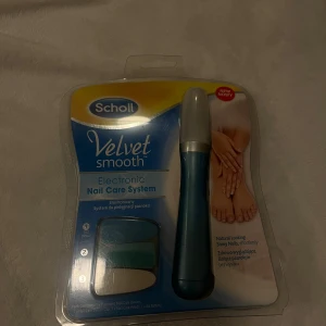 Velvet Smooth Electronic Nail Care System - Scholl Velvet Smooth Electronic Nail Care System för enkel och effektiv nagelvård. Innehåller elektrisk nagelfil, tre sliphuvuden och batteri. Produkten är ny i obruten förpackning