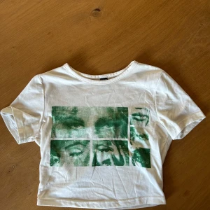 Vit t-shirt med grönt ansiktstryck från SHEIN - Vit t-shirt från SHEIN med coolt grönt tryck av ansikten i olika rutor på framsidan. 