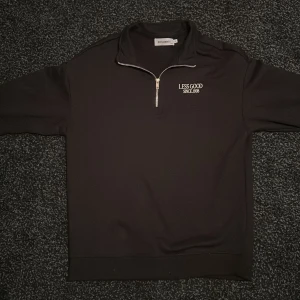 Svart half zip-tröja från New Garments - Svart långärmad tröja från New Garments med halv dragkedja och broderad vit text 'LESS GOOD SINCE. 1998' på bröstet. Skön och enkel modell med hög krage, perfekt för lager-på-lager. Materialet är mjukt och känns som bomullsmix. Jag ha rinte använt den så den är oanvänt för att den tröjan var stor till mig. Också tröjan är baggy