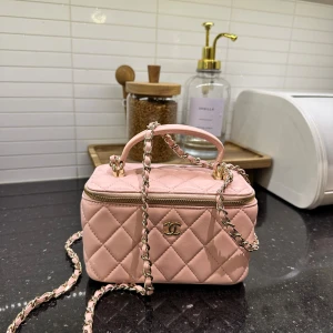 Rosa quiltad handväska - Supersöt rosa handväska från i quiltat skinn med guldfärgade detaljer och kedja. Väskan har en boxig form, dragkedja runt om och spegel på insidan av locket. Perfekt för essentials och har smarta fack för kort. Ikonisk CC-logga framtill.