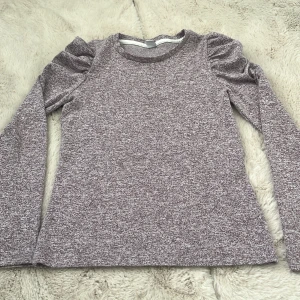 Ljuslila långärmad tröja Lindex - Superfin ljuslila långärmad tröja från Lindex med puffiga axlar. Melerad look och rund halsringning. Perfekt för dig som gillar en enkel men ändå trendig stil. Står 146-152 men skulle även säga XS