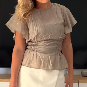Beige blus med volangärm - Superfint blus från HM endast använd 2 gånger i dn olivgrön färg. 💕💕💕xs sann i storlek 