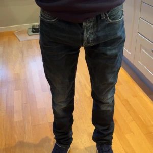 Mörkblå slim fit jeansbyxor från replay - Säljer ett par mörkblå replay jeans med klassisk femficksdesign och snygga slitningar. Jeansen är slim fit, perfekta för en avslappnad stil. Materialet är robust denim i bomull och de har tydliga kontrastsömmar. W 29 L 34