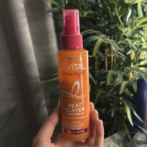 L'Oréal Elvital Heat Slayer Spray - L'Oréal Elvital Dream Length Heat Slayer Iron Spray är en orange sprayflaska med rosa lock. Den innehåller vitamin och ricinolja och skyddar håret mot värme. Perfekt för dig som vill ha långt, glansigt hår och skydda mot värmeskador. Mer än hälften kvar