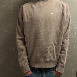 Nike sweatshirt  - Säljer en beige Nike sweatshirt i storlek M. I ett riktigt bra skick. Nypris: ca 1000kr. Modell 183cm