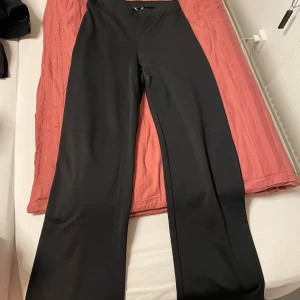 Svarta vida byxor från SBetro - Svarta byxor från SBetro i storlek M. De har en hög midja och vida ben, vilket ger en snygg och avslappnad look. 