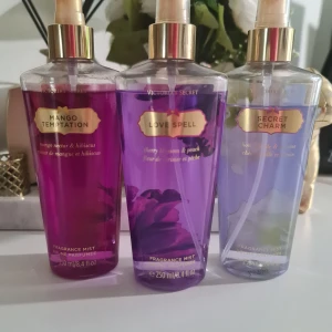 Victoria's Secret Fragrance Mist trio - Tre fräscha body mists: Mango Temptation (mango nectar & hibiscus), Love Spell (cherry blossom & peach) och Secret Charm (honeysuckle & jasmine). Varje flaska innehåller 250 ml. Perfekt för dig som vill ha en lätt och uppfriskande doft. Innehåller aloe vera och kamomill. OBS !!! KORKEN PÅ MANGO TEMPTATION ÄR BORTA SE PÅ BILDERNA . Använda några gånger, se bilder för mängd