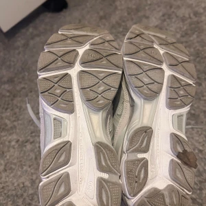 Grå ASICS sneakers med mesh och skinn - Säljer ett par snygga ASICS sneakers i ljusgrått och vitt. Skorna har en sportig design med meshpaneler för bra ventilation och detaljer i syntet och skinn. Klassisk snörning och rund tå, perfekt för dig som gillar stilrena och bekväma sneakers.