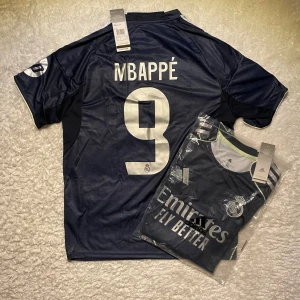 Real Madrid mbappe tröja 25/26 - Helt ny Real Madrid fotbollströja. Perfekt för fans, vardagskläder eller samlare. Storlek: M Snabb leverans 🚚 Kontakta oss gärna om du har några frågor!