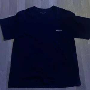 Mörkblå t-shirt Jack & Jones Originals XS - Snygg mörkblå t-shirt från Jack & Jones Originals i storlek XS. Framsidan har en liten Originals-logga och baksidan har ett stort tryck med texten 'Le Ponton Montpellier' och en cool växtillustration. Skön passform och tillverkad i mjuk bomull.