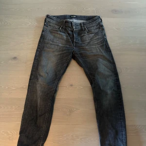 Svarta tapered jeans från Jack & Jones - Säljer ett par svarta jeans från Jack & Jones i modellen Tapered Mike. Jeansen har en snygg tvättad look, klassisk femficksdesign och smalnar av nedtill för en modern siluett. Perfekta för dig som gillar en stilren och avslappnad vibe. Stl 30/30