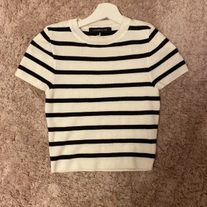 Randig stickad topp - Kortärmad topp i vit och svart med klassiskt horisontellt randigt mönster! 🖤🤍 Stickad i mjukt material med rund halsringning och normal passform. Köpt i Thailand och storleken på tröjan är ungefär XS! 🩷Aldrig använd ❤️