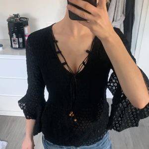 Vintage virkad blus med snörning - Sjukt cool vintage virkad blus med v-ringning och snörning framtill, dekorerad med små träpärlor. Blusen har trekvartsärmar med volang och ett genombrutet mönster som ger en luftig känsla. Står in n storlek i men skulle säga att den motsvarar XS. Tror den kostade mellan 300 och 500 kr. Hör av dig vid frågor💕