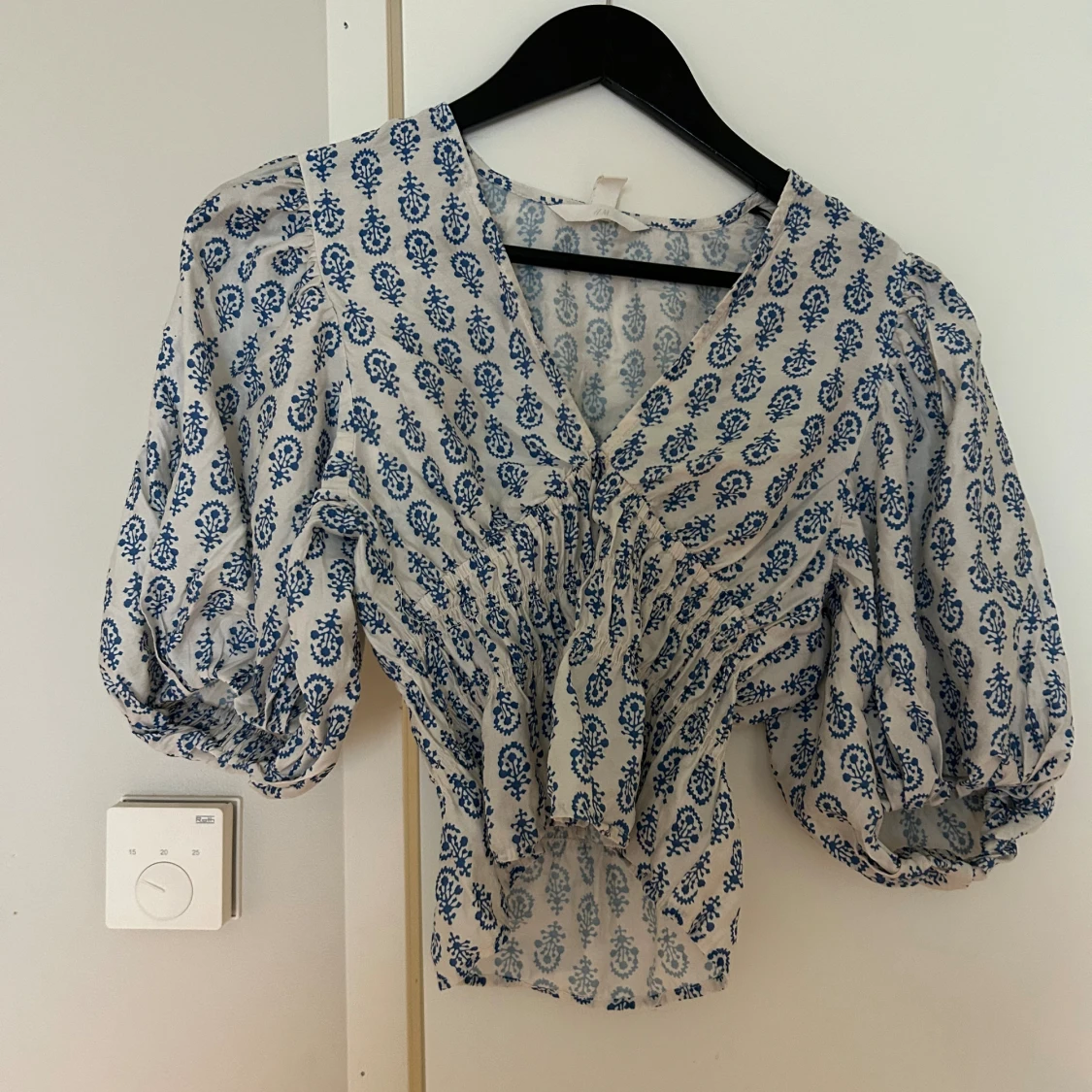 Vit och blå blommig blus med puffärm