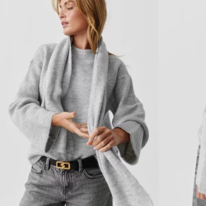 stickad tröjä - Mysig ljusgrå stickad kofta med bred sjalkrage och vida ärmar. Perfekt att slänga på sig över en t-shirt eller topp för en chill och stilren look. Koftan har en avslappnad passform och är superenkel att matcha med jeans.