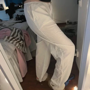 Vita loose mjukisbyxor med snörning - Säljer ett par vita linnebyxor med loose passform och resår i midjan. Byxorna har snörning i midjan för extra komfort och är raka i benen. Perfekta för en chill och avslappnad stil.