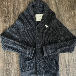 Abercrombie & Fitch stickad cardigan - Säljer nu denna stickade cardiganen från Abercrombie & Fitch! Den är använd några gånger men är i ett superbra skick. Perfekt att ha nu när det börjar bli kallare ute. Skick 9/10