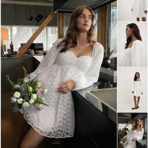 Vitblommig studentklänning från NA-KD - Supersöt vit kortklänning från NA-KD med blommigt spetsmönster, långärmad och med söt hjärtformad urringning. Klänningen har en luftig passform och är perfekt för studenten. Materialet är lätt och känns riktigt fräscht. Endast använd en gång.