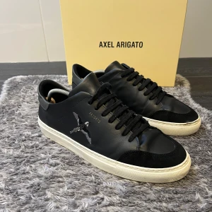 Axel Arigato Clean 90 B Bird Sneakers - Populära Clean 90 B Bird sneakers från svenska Axel Arigato i storlek 43. Stilren vit lädersneaker med ikonisk fågel-detalj. Fint använt skick förutom en liten lagning fram på ena skon (se bilder), inget som påverkar användningen eller helhetsintrycket.