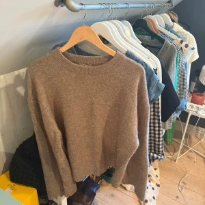 Beige stickad tröja från Gina Tricot - Mysig beige stickad tröja från Gina Tricot i storlek S. Tröjan har rund halsringning, långa ärmar och ribbade muddar vid hals, ärmslut och nederkant. Perfekt för lager-på-lager och chill dagar.
