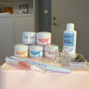 Nagel akryl set - Fem olika akrylpulver, Den rosa är öppnad och använd väldigt lite, märks inte Resten är oöppnade Akrylvätska som har mycket mer än hälften kvar  Liten glasskål till alrylvätskan Nagelfil 100/180 grit  Nagel cuticle oil  Papper nagel extensions 24 st