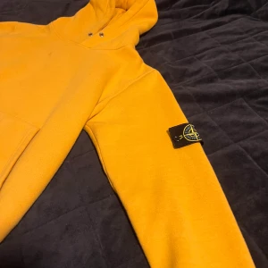 Gul stoneisland hoodie  - Gul hoodie från stoneisland, riktigt skön att ha på och bra kvalité. Ända nackdelen är att det finns några fläckar på den som syns på bild men kanske går bort. Storlek L, hör av er vid intresse 