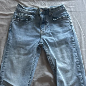 Ljusblå bootcut jeans med vida ben - Snygga ljusblå jeans från Perfect Jeans med klassisk femficksdesign och bootcut passform. Jeansen har vida ben och normal midja, tillverkade i mjukt denimtyg. Perfekta för dig som gillar retrovibbar och en avslappnad stil.