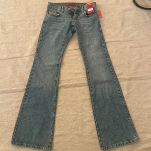 Redstar vintage low waist jeans blå - Säljer ett par klassiska redstar jeans i blå denim med bootcut-modell och låg midja . Byxorna har fem fickor, bälteshällor och stängs med knapp och dragkedja. Storlek:27/34. Innerbensmått 66cm 