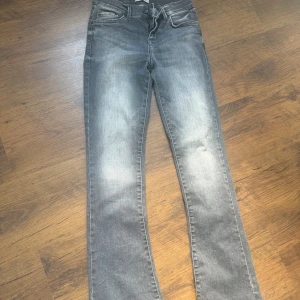 Grå flare jeans från LTB - Snygga grå jeans från LTB med flare passform och klassisk femficksdesign. Jeansen har en tvättad look med ljusare partier framtill och är tillverkade i mjukt denimtyg. Perfekta för dig som gillar en trendig och avslappnad stil.