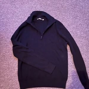  half zip tröja från Dobber - Mörkblå långärmad tröja från Dobber i storlek S. Tröjan har en snygg half zip-dragkedja vid kragen och är tillverkad i ett mjukt material som känns skönt mot huden. Perfekt för lager-på-lager och stilren look. Inte använd en ända gång