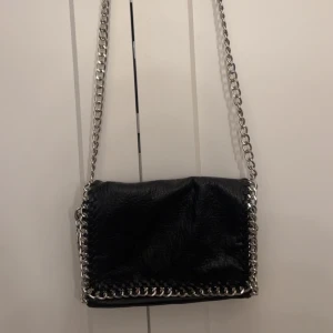 Svart tiamo väska - Svart tiamo väska som inte kommer till användning längre. Den har inga täcken på användning och är som ny. Bredd: 9 cm. Djup: 18 cm. Längd: 27 cm.💞