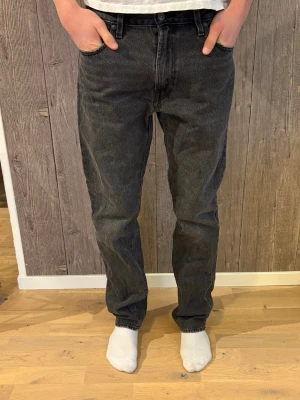 Levi's 551 svarta jeans W30 L34 - Svarta Levi's 551 jeans med klassisk femficksdesign och rak passform. Jeansen har en mörk tvätt. Jeansen är oanvända