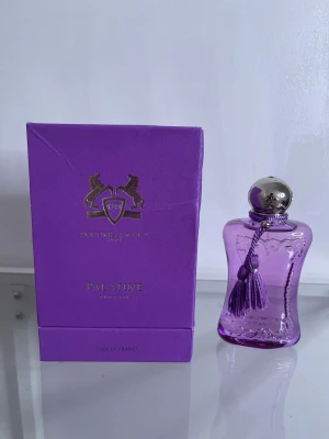 Palatine Eau de Parfum 75ml - Lyxig parfym från Parfums de Marly Paris. Snygg lila flaska med dekorativ tofs. Volym: 75 ml. Perfekt för dig som vill sticka ut med en exklusiv doft.