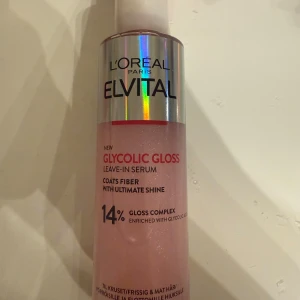 L'Oréal Elvital Glycolic Gloss Serum - L'Oréal Elvital Glycolic Gloss Leave-In Serum med 14% gloss complex och glykolsyra. Ger intensiv glans och mjukhet till håret. Kommer i en rosa plastflaska med holografisk etikett, 150 ml. Perfekt för frissigt och matt hår.