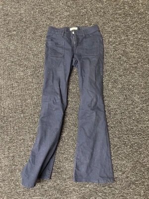 Mörkblå bootcut byxor från Lindex - Förlåt att de var lite samma på byxorna de går att borsta bort men såg inte förens nu Mörkblå byxor från Lindex i modellen Freja, storlek 158. Byxorna har bootcut-ben, två stora fickor fram och hällor för bälte. Tillverkade i ett mjukt bomullstyg som är skönt att bära. Perfekta för dig som gillar en klassisk men trendig look.