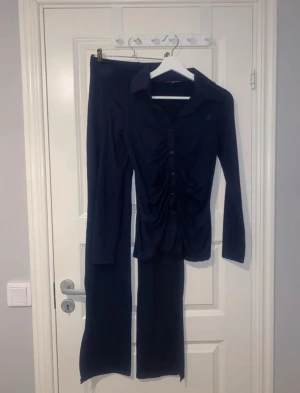 Set i navy - Otroligt skönt material, känns som mjukis men ser så elegant ut. Skjorta med byxor som har vita ben och slits. Använd 1 gång
