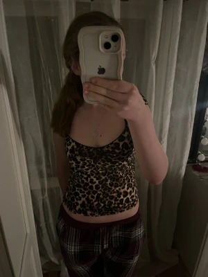 Leopardmönstrad topp från Nelly - Säljer en leopardmönstrad topp från Nelly i storlek XS. Toppen har v-ringad hals, smala axelband och är figurnära. Färgerna är beige och svart med bruna inslag. Materialet känns mjukt och stretchigt, perfekt för dig som gillar djurmönster och vill sticka ut. Haft den på mig en gång i 5 minuter då jag bara provat den men för min del tyckte inte jag att färgen passade mig🩷
