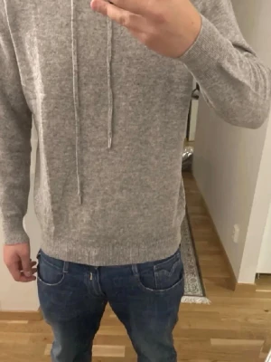 Grå Kashmir Hoodie - Säljer en riktigt fet beige kashmir/merinoull hoodie i storleken S. Den är i nyskick. Tröjan är i toppkvalite och är blandning mellan kashmir och merinoull. Skriv om du har några funderingar (mått, passform, pris, bilder). Mvh KC Closet.