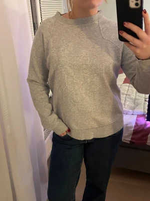 Grå sweatshirt från Monki, stl S - En enkel och chill grå sweatshirt från Monki i storlek S. Tröjan har rund hals, ribbade muddar och är långärmad. Passformen är normal och färgen är ljusgrå.