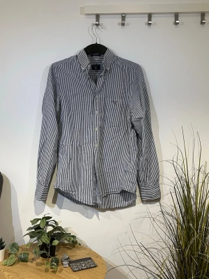 Gant Randig skjorta  - Randig Skjorta från Gant. Den är i storlek S och passar perfekt för dig som gillar stilrena och tidlösa plagg. Modellen är 175cm. Den är i mycket bra skick. Skriv privat för mer info🤗