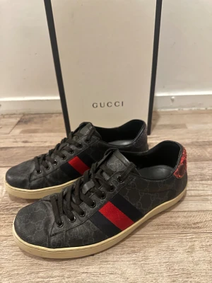 Gucci ace skor - Gucci ace skor i fint skick finns defekt i bak och ett litet skrap sår i fram. Har tyvärr inte kvar kvitto på skorna det som medföljer är endast sko lådan.