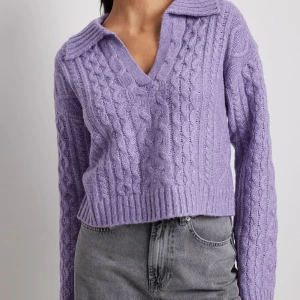 Lila stickad tröja med krage - Säljer en snygg lila stickad tröja med krage och v-ringning. Tröjan har ett flätat mönster och är croppad med långa ärmar. Perfekt för kyligare dagar! Skriv för bild på min tröja. 