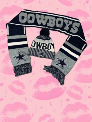 Dallas Cowboys stickad halsduk & mössa - Snyggt set med stickad halsduk och mössa från Dallas Cowboys, NFL. Halsduken har stora COWBOYS-bokstäver och broderade stjärnor, mössan har pompom och matchande stjärna framtill. Färgerna är mörkblå, grå och vit med ränder och fransar. Perfekt för dig som gillar amerikansk fotboll.