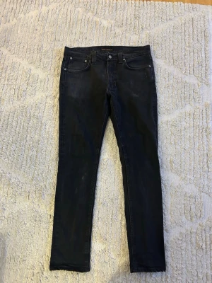 Svarta Nudie Jeans  - Säljer ett par svarta Nudie Jeans som är i bra skick. Säljer detta par eftersom jag börjat använda baggy jeans , annars ett väldigt bra och fint par. Nypris 1600kr, jag säljer dessa för 800kr. (32W 32L)