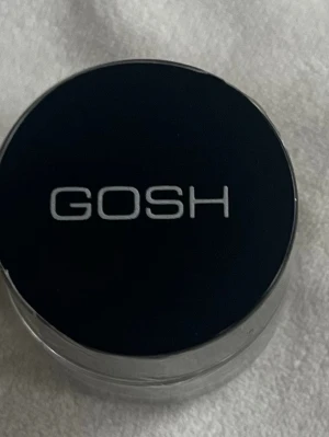 GOSH Effect Powder 06 Greeny - Säljer en GOSH Effect Powder i färgen 06 Greeny. Det är ett löst pigment i en liten rund burk med svart lock och transparent underdel. Färgen är skimrande grön, perfekt för att skapa coola ögonlooks eller använda som ögonskugga. Kommer i plastförpackning.