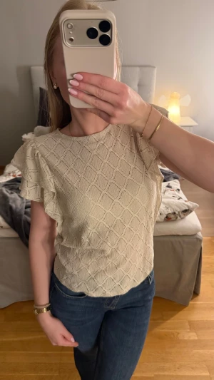 Volang topp med mönster - Volang topp från Lindex i storlek S. Den är beige och tyget är mönstrat. Ärmen består av två volanger som är super söta. Toppen är aldrig använd och därför är den i nytt skick. Hör gärna av dig vid frågor🤎