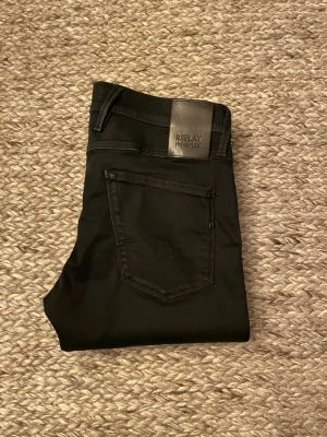 Replay Hyperflex Anbass svarta jeans - Svarta Replay Hyperflex Anbass jeans med slim fit och klassisk femficksdesign. Byxorna har normal midja, smal passform och är tillverkade i stretchigt jeansmaterial för extra komfort. Storlek 29/32. //David