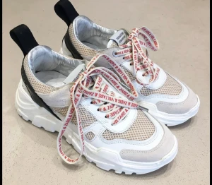 Chunky sneakers från Zadig & Voltaire - Säljer ett par chunky sneakers från Zadig & Voltaire med vit och beige mesh, detaljer i mocka och skinn samt svart häl. Skorna har tjock vit sula och snörning med röda logoband. 