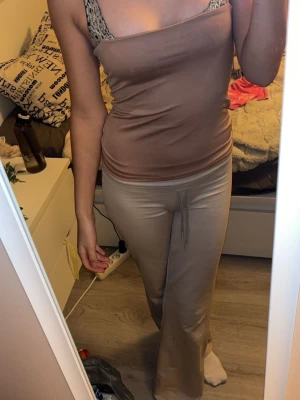  Beige  linne med snöre  - Säljer ett par beige mjukisbyxor med snörning i midjan. Byxorna har en loose passform och är tillverkade i ett mjukt material som känns skönt mot huden. Perfekta för chill dagar och har en enkel, stilren look.